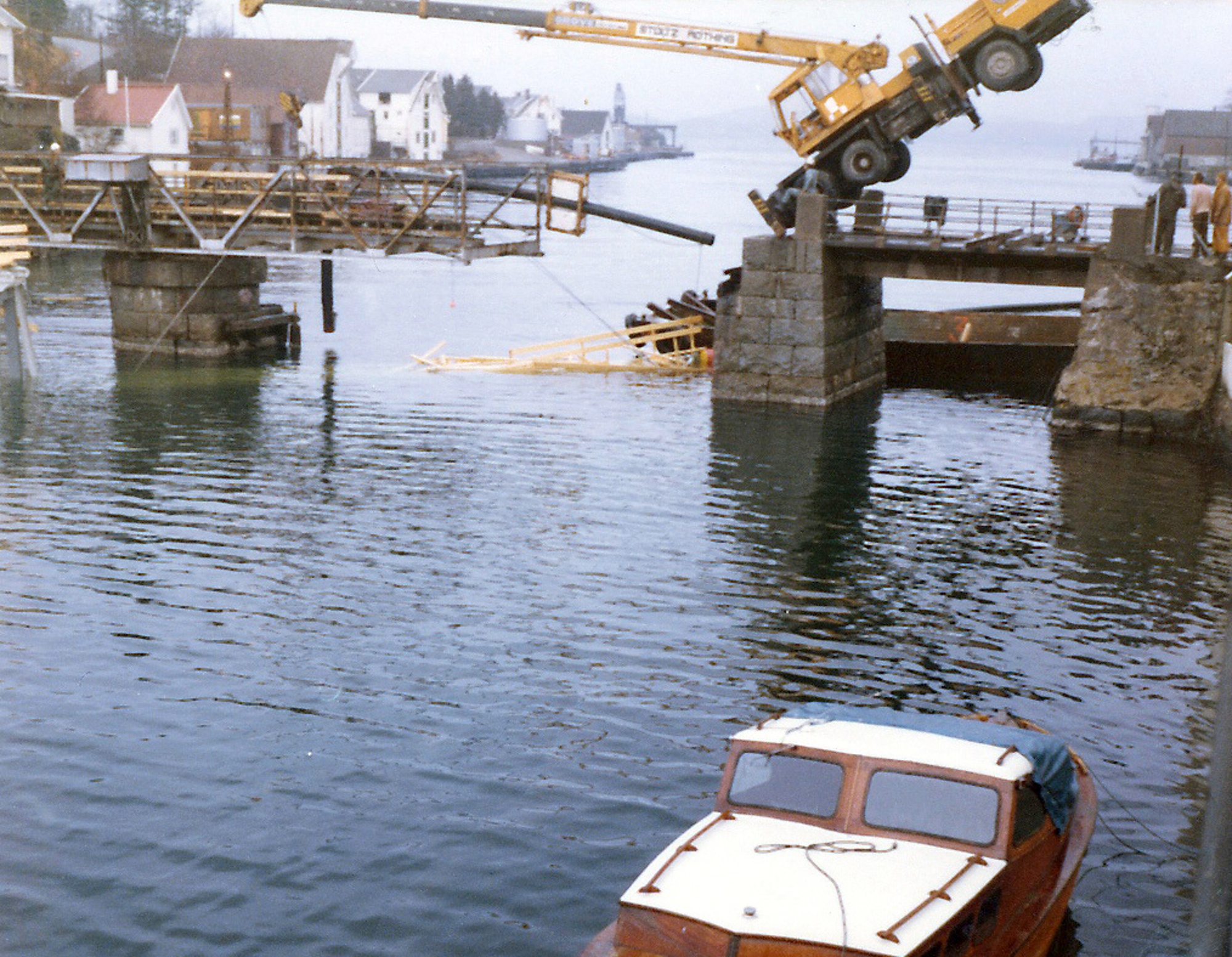 Strømsund bro (1929 - 1978) Rivingen av svingbroen har startet for å gi plass til den nye vippebroen. Kranen klarte ikke vekten av gangbroen og holdt på å gå i sjøen ...  Strømsund bru på riksvei 511 i Karmøy er et viktig kulturminne. Helt siden 1873 har det stått en bru her som binder nordre og søndre del av Kopervik sammen. Dette er et av få steder i landet der man har hatt flere generasjoner av bevegelige bruer. Dagens bru er 52 meter lang og den tredje i rekken. Brua var den første klaffebrua i Norge med hydraulisk drift. Strømsund bru ble fredet av riksantikvaren i 2008, og står nå som en viktig brikke i fortellingen om den nasjonale veg- og samferdselshistorien. Hensikten er å bevare hovedkonstruksjoner og detaljer, og at den også i fremtiden skal være bevegelig. (Aud Irene Jacobsen - Karmøy kommune)