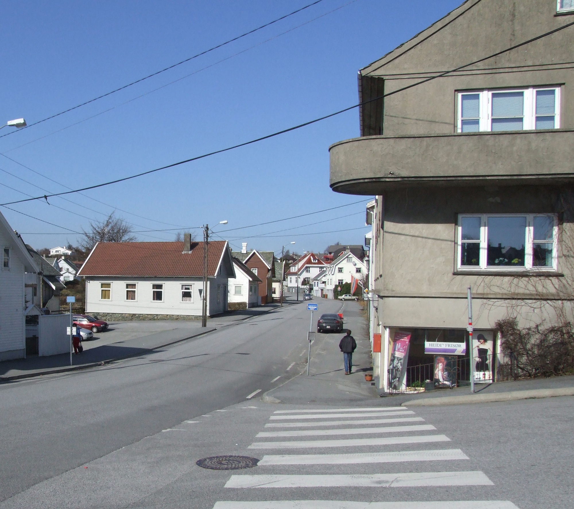 Bygninger i Kopervik Norasiå og Avaldsnesvegen På venste side ser vi Losjen (Rotary). På høyre side murhuset som ble bygd av dr. Næss og hvor kolonialbutikken Husholdningen holdt til på gatenivå. Husholdningen ble drevet av Alf Nilsen ... Helt i enden av vegen på høyre side ser vi Sverre (Pelle) Vea, Djønne/Lanes og Henrik Enochsen sine hus ...