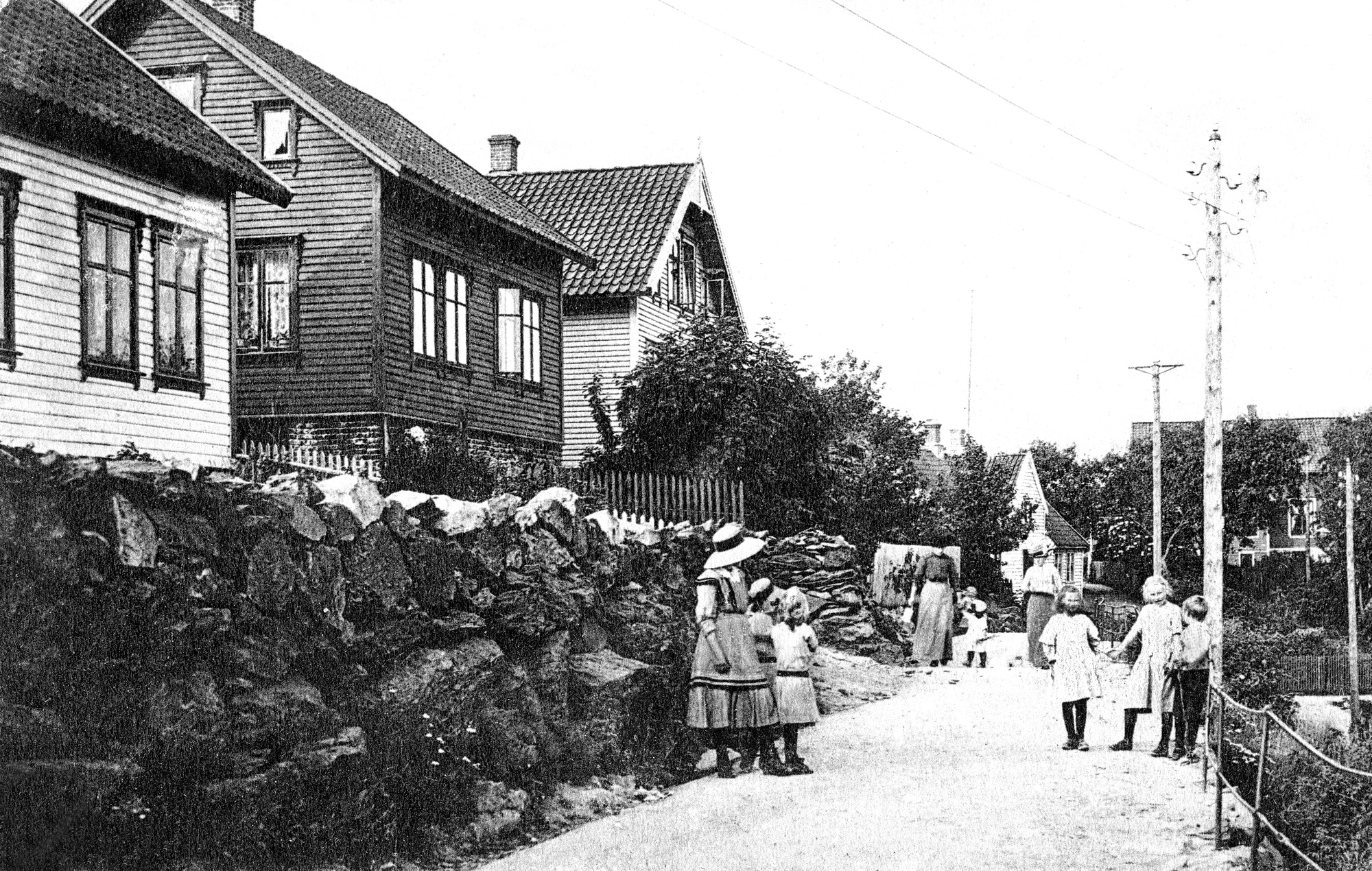 Liv og røre i Roald Amundsensens gate ... I bakgrunnen ser vi Mathahuset og den tidligere presteboligen ... Husene fra venstre er: Lars Kristian Melkevik, Jakob Håvarstein og Toralf Eilertsen ...  ?