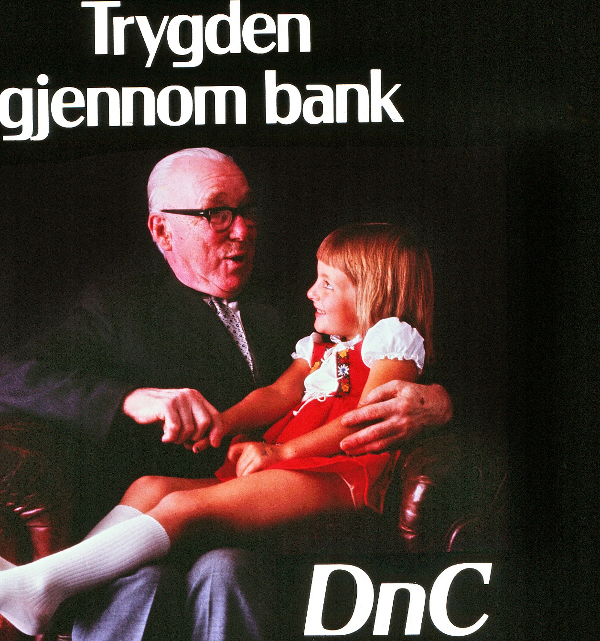 Trygden gjennom bank fra DNC, Den norske Creditbank  Lysbilde i glass i stort format for bruk til kinoreklame. Disse lysbildene ble brukt sammen med filmreklame helt til den digitale tidsalder inntok kinoene ...