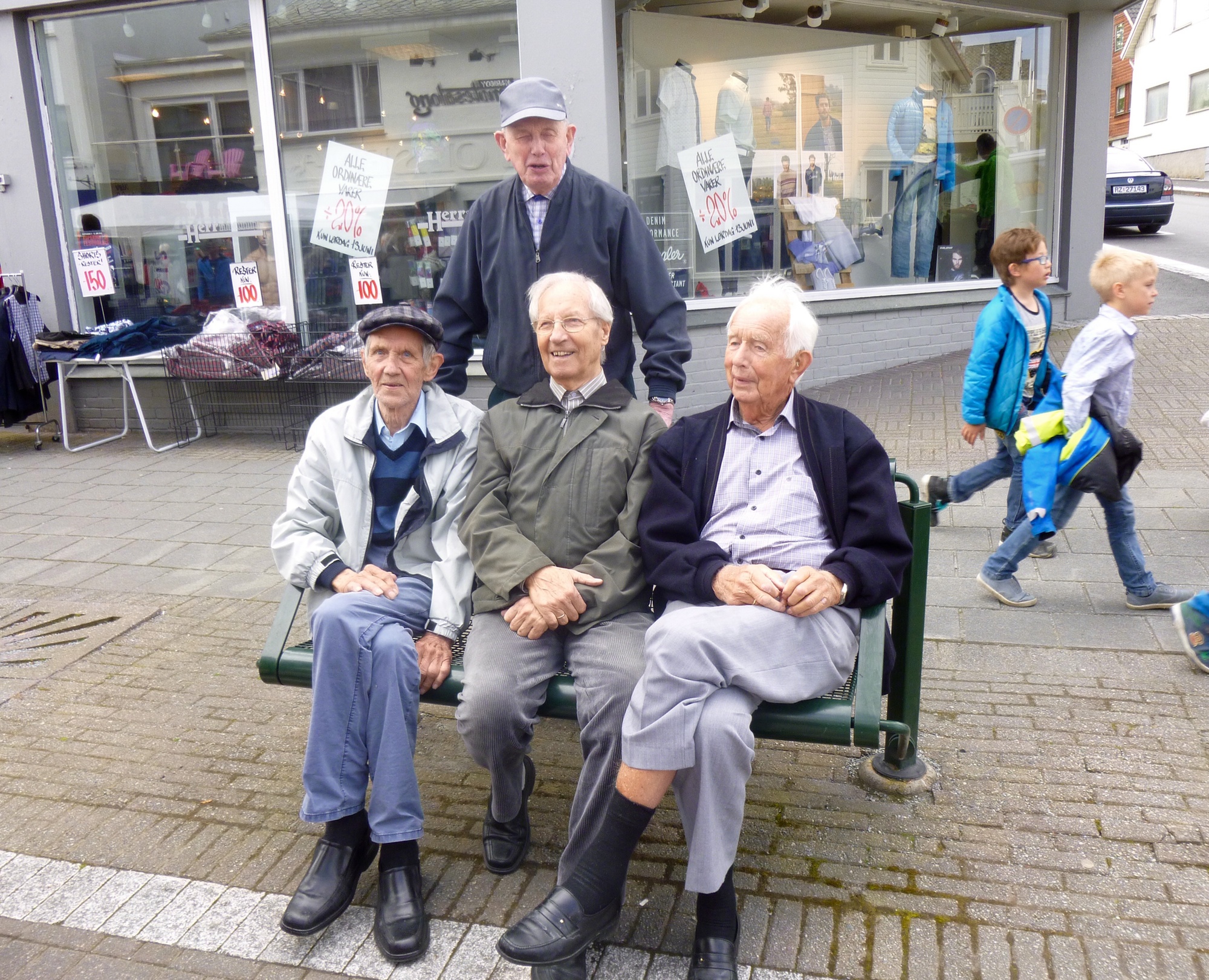 På en benk i Hovedgaten ...  Foran fra venstre: Alf Lundberg, Valter Vorraa, Magne Kolbeinsen Bak står Leiv Stangeland