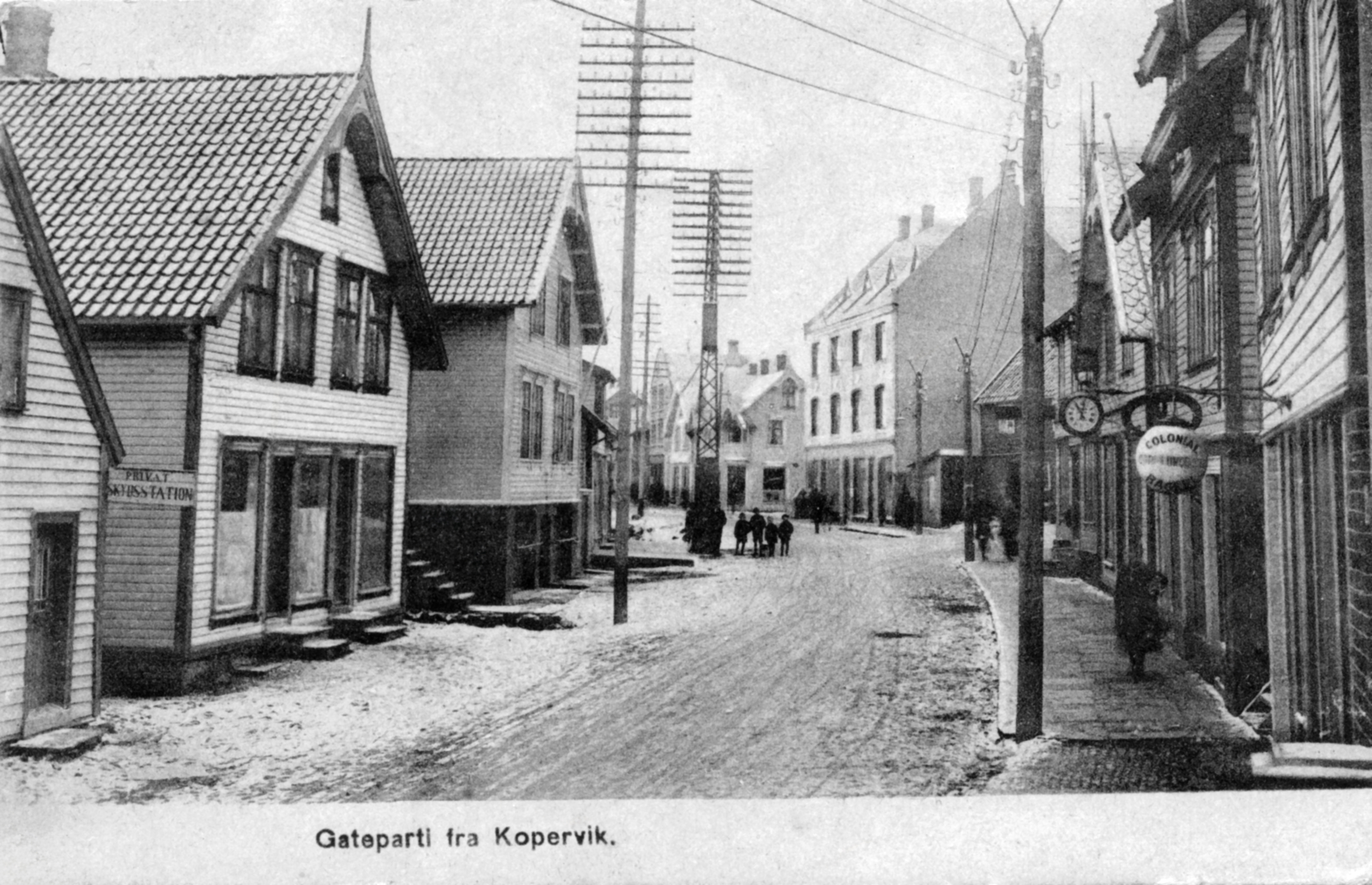 Bygninger i Kopervik Hovedgaten fra baker Carl A. Lundberg, urmaker Opsahl, senere Damman, så skomakermester Hans O. Grimstvedt og i hjørnehuset snekkermester Kolbein Skaar, Egenessmien (til 1935), Karmøen Kreditbank og Mydlandlandhuset På venstre side: ? og Wathne
